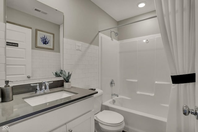 bathroom featuring tile walls, visible vents, shower / bathtub combination with curtain, toilet, and vanity