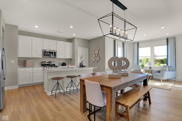 dining room featuring baseboards, light wood-style flooring, and recessed lighting