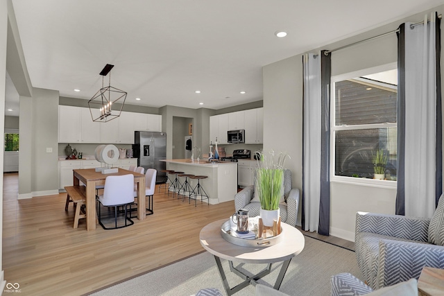 living area with light wood-type flooring, baseboards, and recessed lighting