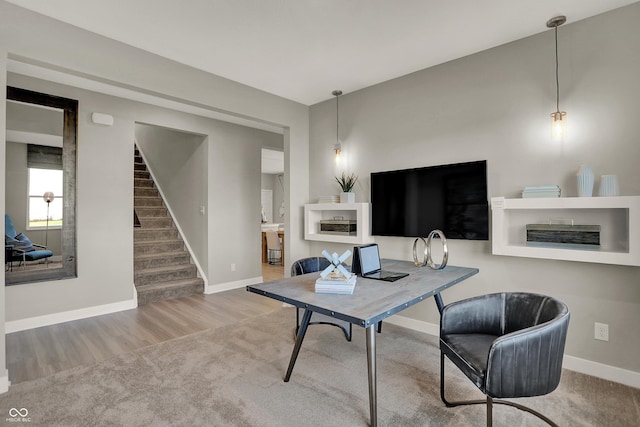 living room with carpet floors, baseboards, stairway, and wood finished floors