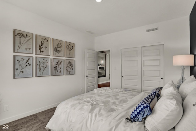 carpeted bedroom featuring a closet, visible vents, and baseboards