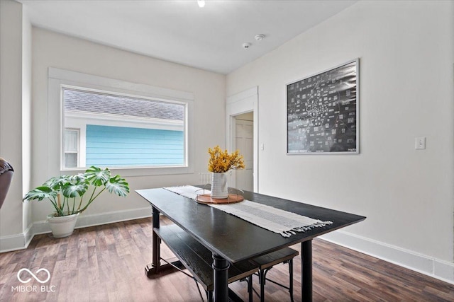 dining space featuring baseboards and wood finished floors