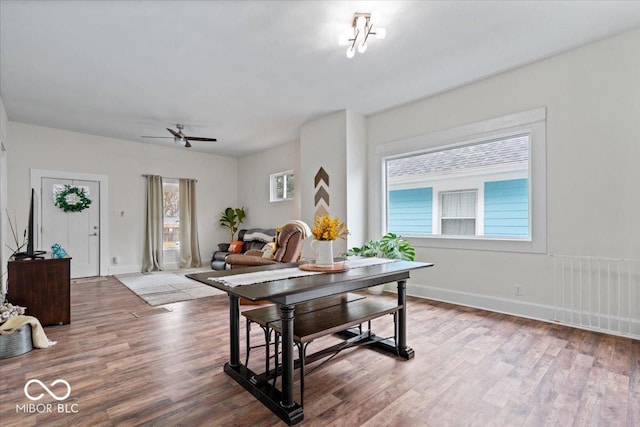 dining area with a ceiling fan, baseboards, and wood finished floors