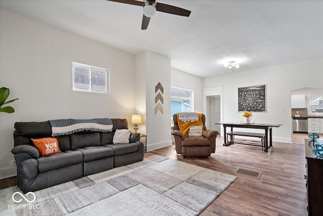 living room with baseboards, visible vents, and wood finished floors