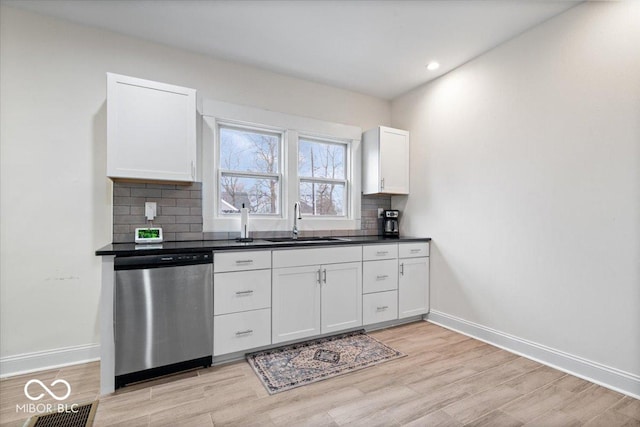 kitchen with dishwasher, a sink, visible vents, and decorative backsplash