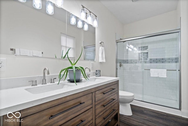 full bath featuring toilet, a stall shower, and a sink