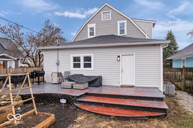 back of property with roof with shingles, fence, central AC, and a wooden deck