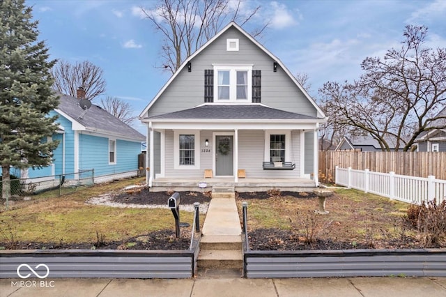 dutch colonial with a porch and fence