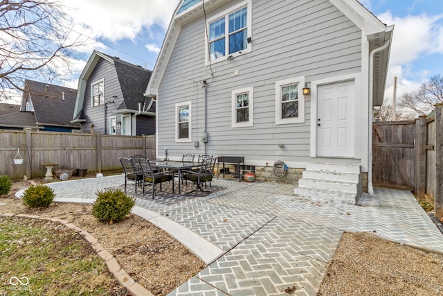 rear view of property with entry steps, a patio area, and a fenced backyard