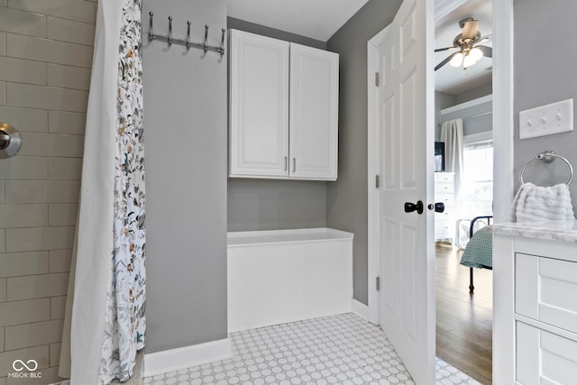 full bathroom featuring a shower with curtain, ceiling fan, and baseboards