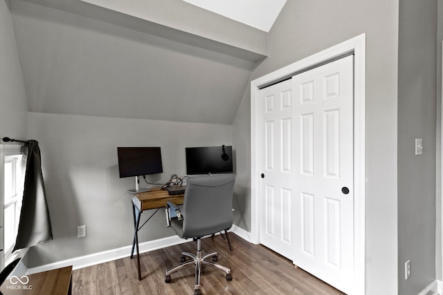 office space featuring vaulted ceiling, wood finished floors, and baseboards