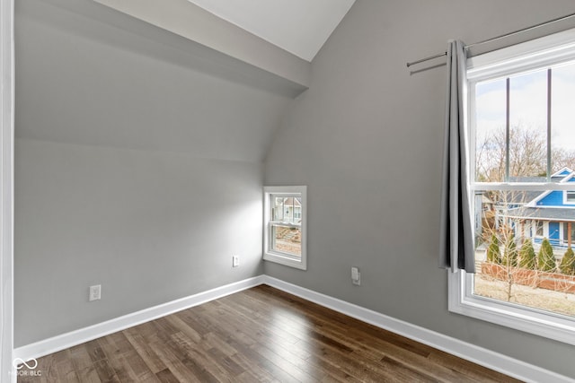 bonus room with dark wood-style floors, lofted ceiling, and baseboards