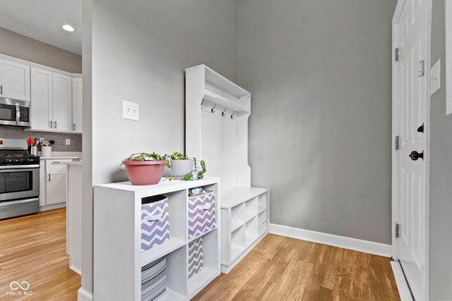 mudroom featuring recessed lighting, light wood-type flooring, and baseboards