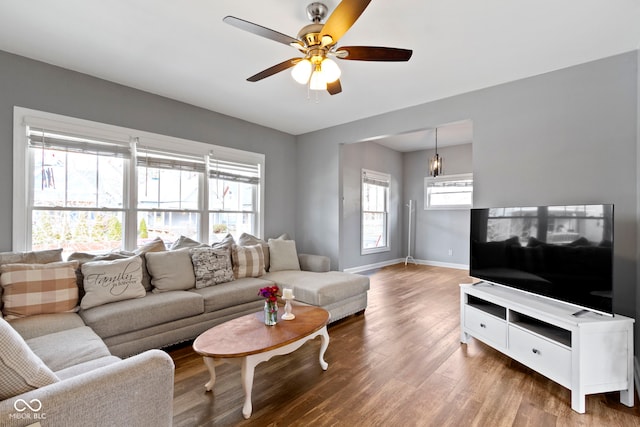 living area featuring ceiling fan, wood finished floors, and baseboards