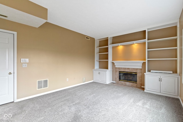 unfurnished living room featuring carpet floors, a tile fireplace, and visible vents