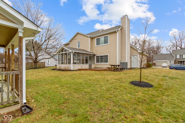 back of house with a sunroom, a lawn, a chimney, and central air condition unit