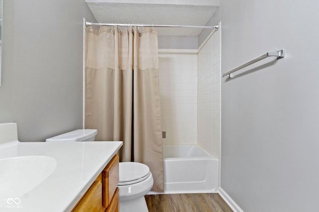 full bathroom featuring baseboards, toilet, wood finished floors, shower / bath combo with shower curtain, and vanity