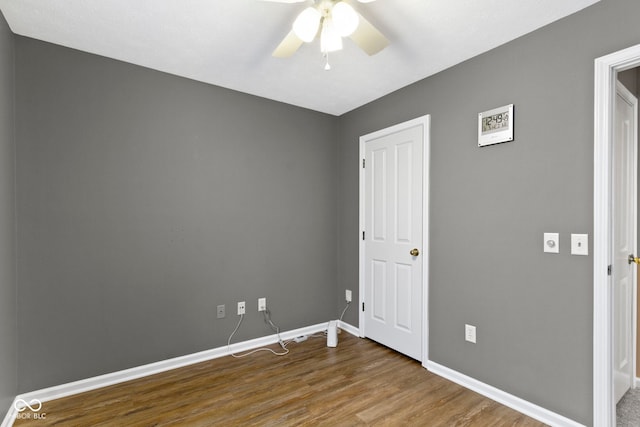 unfurnished bedroom with ceiling fan, baseboards, and wood finished floors