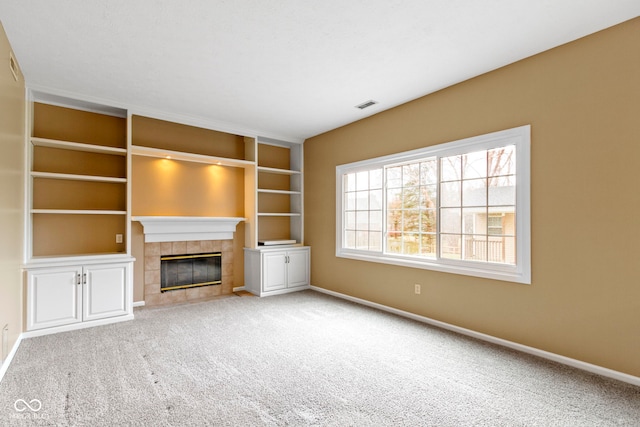 unfurnished living room featuring carpet floors, a fireplace, visible vents, and baseboards