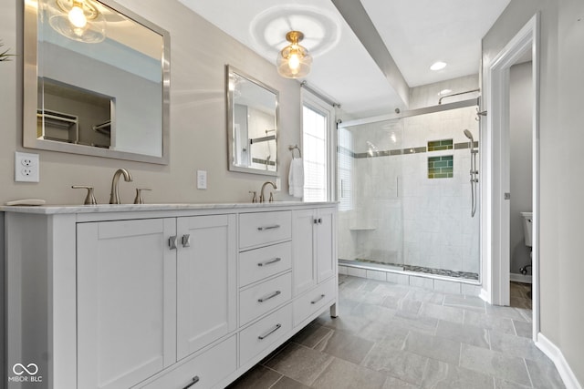 full bath with double vanity, a stall shower, and a sink