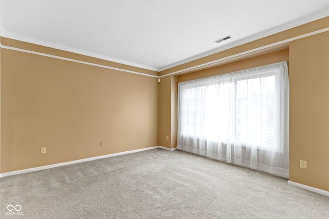 empty room featuring ornamental molding, baseboards, visible vents, and carpet flooring