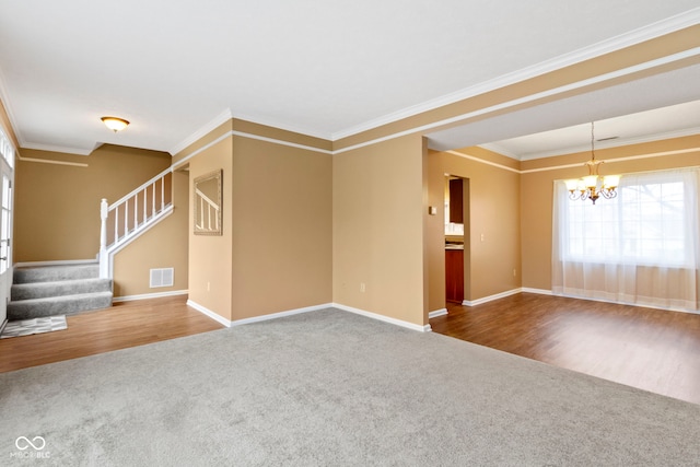 empty room featuring crown molding, a notable chandelier, visible vents, stairway, and carpet flooring