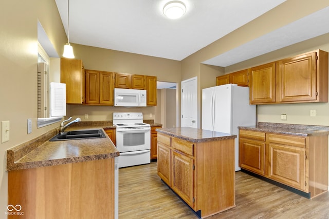 kitchen featuring a center island, white appliances, a sink, and light wood-style flooring