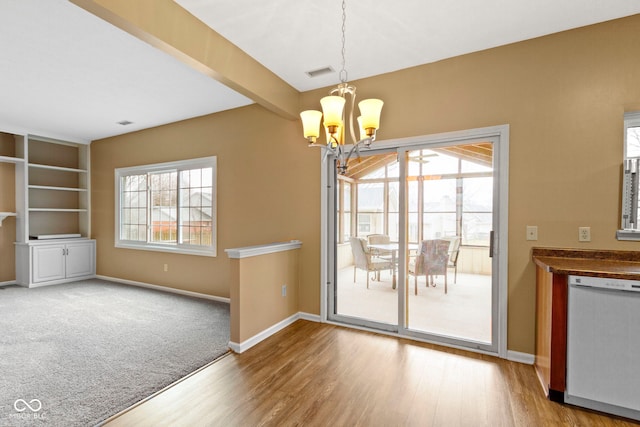 unfurnished dining area featuring baseboards, a chandelier, beamed ceiling, and wood finished floors