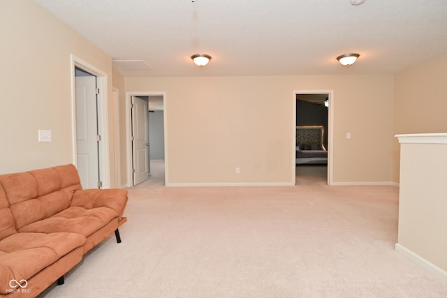 sitting room featuring light carpet and baseboards