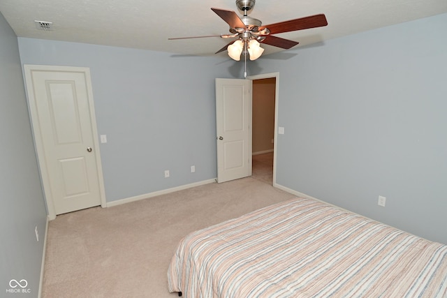 bedroom with light carpet, baseboards, visible vents, and ceiling fan