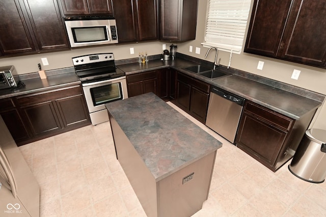 kitchen featuring stainless steel appliances, dark countertops, and a sink