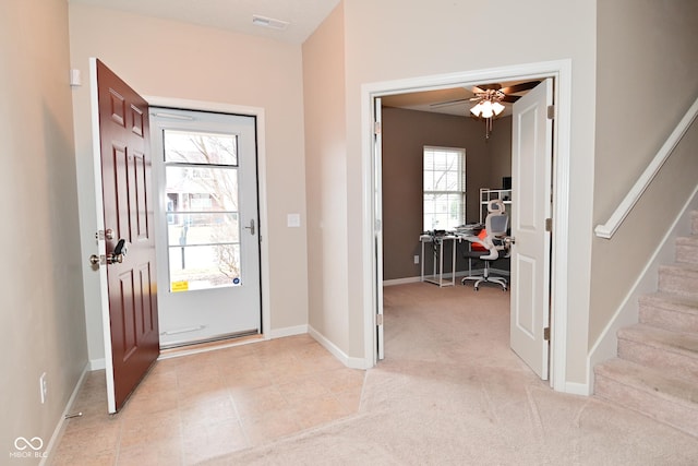 entrance foyer with light carpet, baseboards, stairs, and visible vents