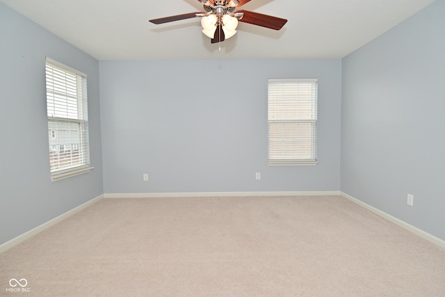 spare room featuring baseboards, ceiling fan, and light colored carpet