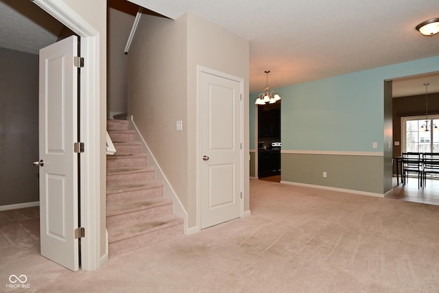 stairway with carpet flooring, a notable chandelier, and baseboards