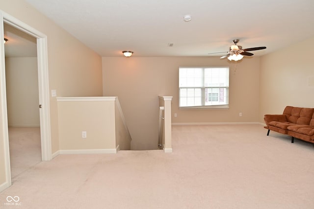 unfurnished room featuring carpet floors, baseboards, and an upstairs landing