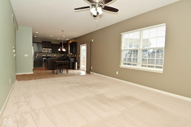 interior space with recessed lighting, light carpet, ceiling fan, and baseboards