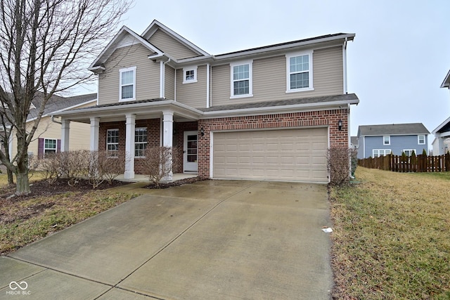 view of front facade with driveway, a front yard, fence, and brick siding