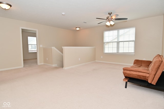 sitting room featuring visible vents, baseboards, light colored carpet, and an upstairs landing