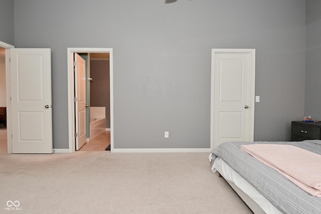 bedroom featuring connected bathroom, baseboards, and carpet flooring