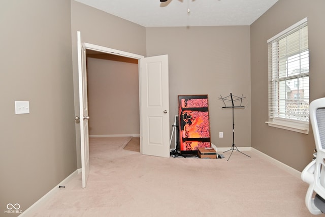 interior space featuring carpet floors, baseboards, and a ceiling fan