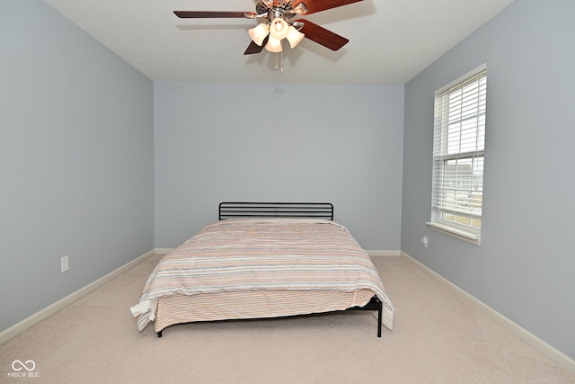 bedroom with light colored carpet, ceiling fan, and baseboards