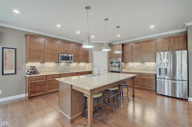 kitchen featuring crown molding, hardwood / wood-style flooring, appliances with stainless steel finishes, and a sink