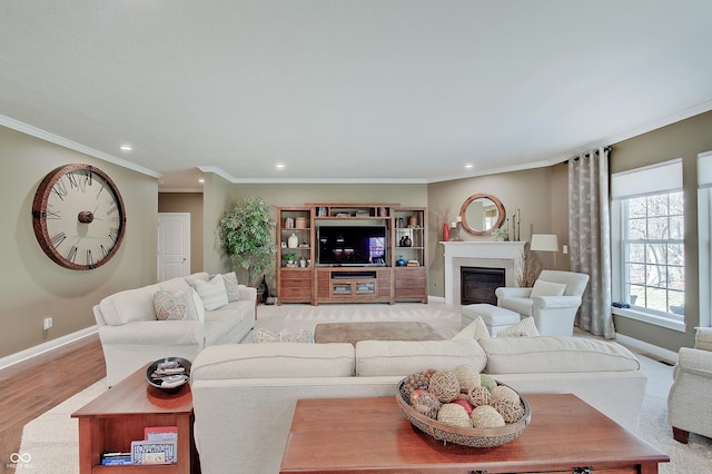 living room featuring a glass covered fireplace, recessed lighting, baseboards, and ornamental molding