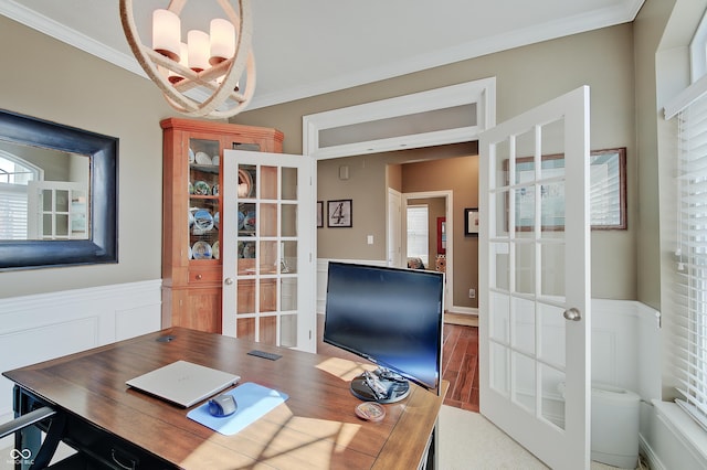 office featuring wood finished floors, french doors, a wainscoted wall, and ornamental molding