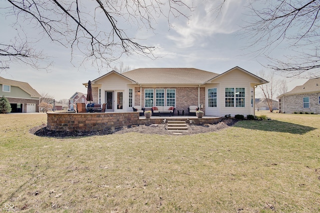 rear view of property with a patio, a yard, french doors, and brick siding