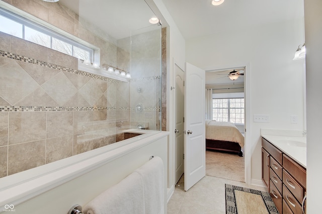 ensuite bathroom with double vanity, a healthy amount of sunlight, ensuite bathroom, and tile patterned flooring