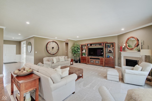 living room featuring recessed lighting, wainscoting, a fireplace, and crown molding