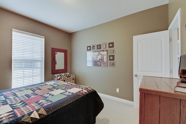 bedroom featuring light carpet and baseboards