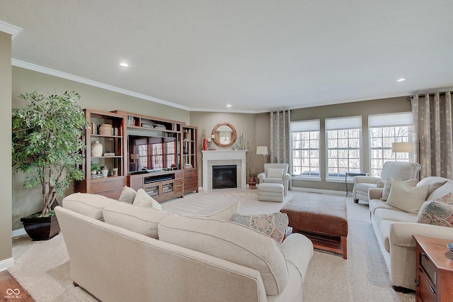 living area featuring recessed lighting, a glass covered fireplace, and crown molding