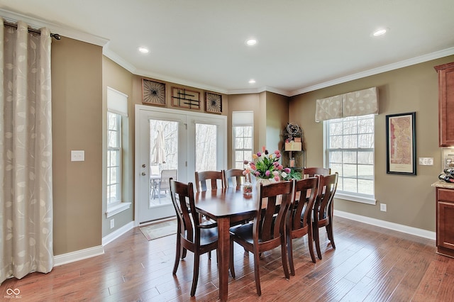 dining space with recessed lighting, crown molding, baseboards, and wood finished floors